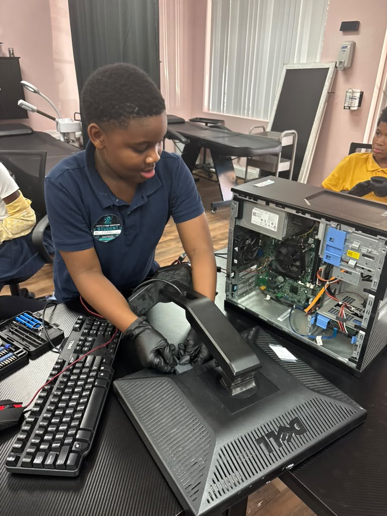 Instructor demonstrating internal desktop wiring and power supply routing to young participants